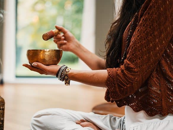 woman in brown knit sweater holding brown ceramic cup